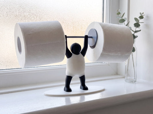 Strongman toilet roll holder on a bathroom windowsill in soft morning light