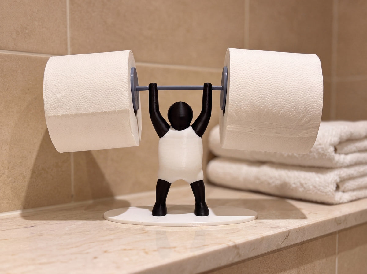 Strongman toilet roll holder on a marble bathroom shelf beside folded white towels