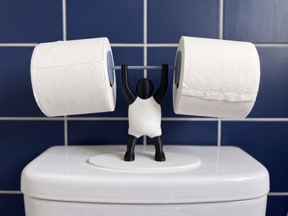 Strongman toilet roll holder on a cistern against navy blue tiles