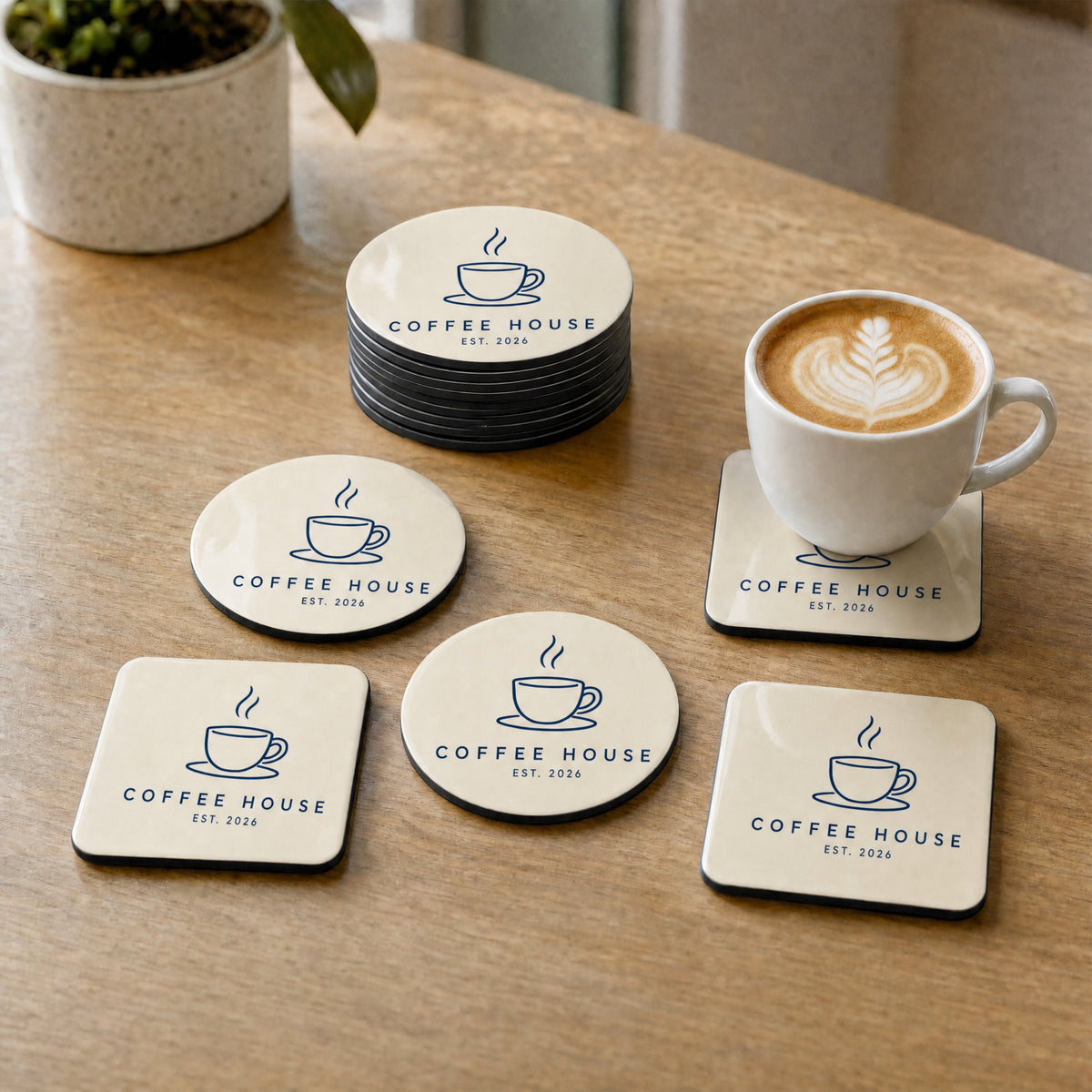 Custom logo coasters for a coffee house, stacked and in use on a cafe table