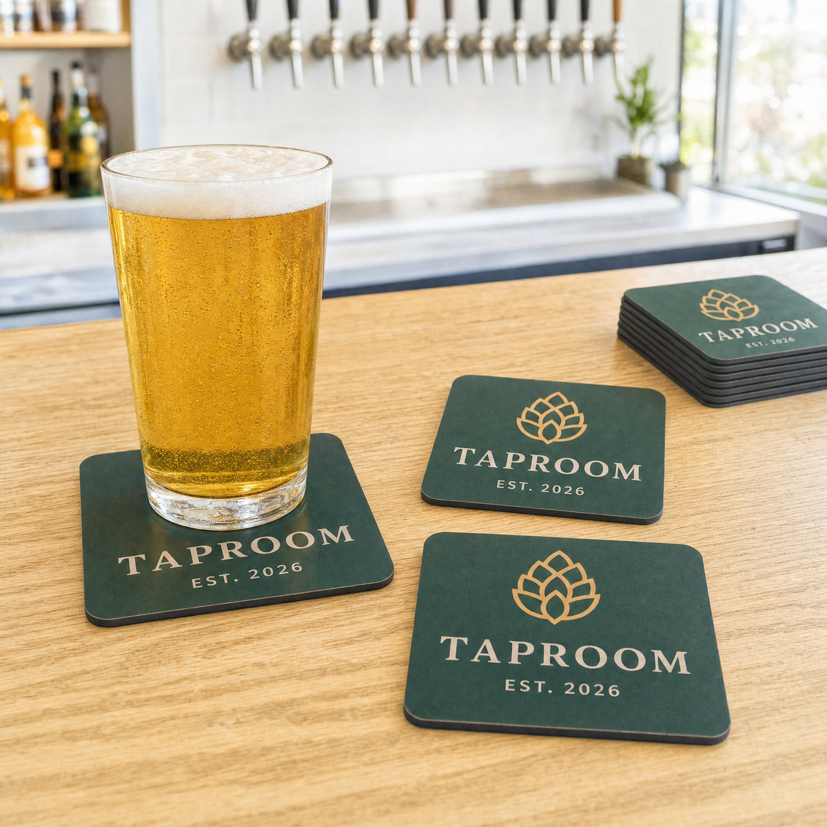 Branded taproom coasters on a bright bar with a pint